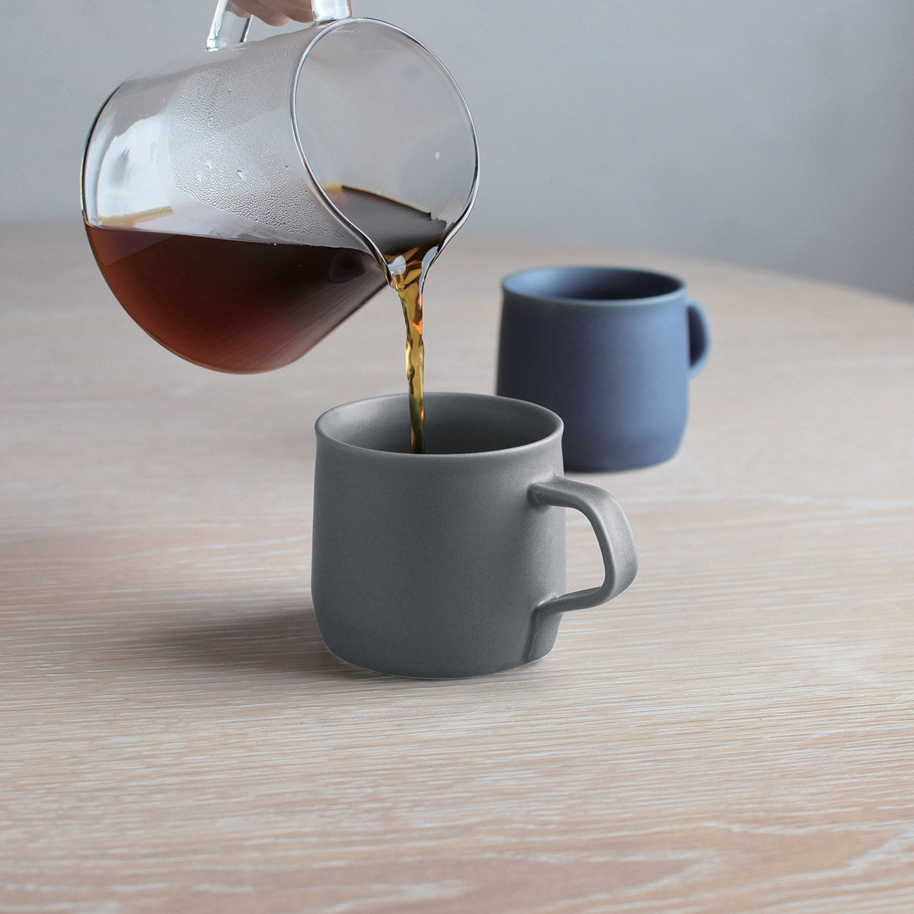 Kinto Fog Mugs with coffee pouring into them